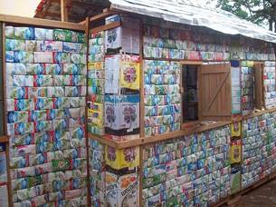 Casa dos sonhos é feita de caixas de leite, caixotes, pneus, garrafas PET e latas de tinta vazias