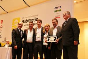 Diretor de Construção, José Antônio Costa Cintra, ao lado de técnicos da Cohab Minas, recebe premiação de reconhecimento à atuação da companhia