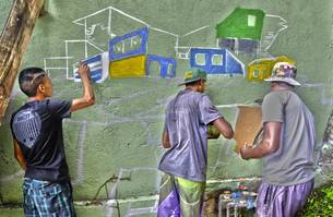 Jovem pinta o Beco Santa Inês, no aglomerado Santa Lúcia em Belo Horizonte
