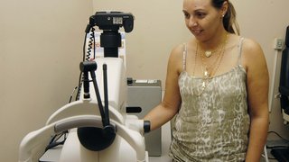 Érica França, gerente dos centros de Brasília de Minas, mostra aparelho para exames de fundo de olho