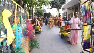 Catadores com carrinhos com recicláveis e índios pataxós no desfile
