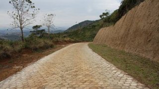 Estrada pavimentada e manta de coco para evitar erosão na encosta