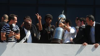 Ronaldinho Gaúcho acena para o público, na Praça Cívica, ao lado do troféu da Copa Libertadores
