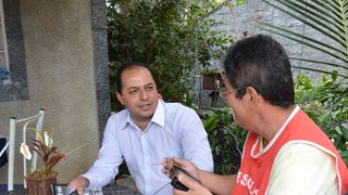 O servidor Cláudio Henrique Fróes recebe em sua casa o recenseador da FJP, Dimas Vander Lima