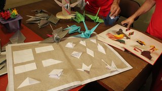 Os integrantes da oficina estão produzindo oito mil origamis para um desfile de joias